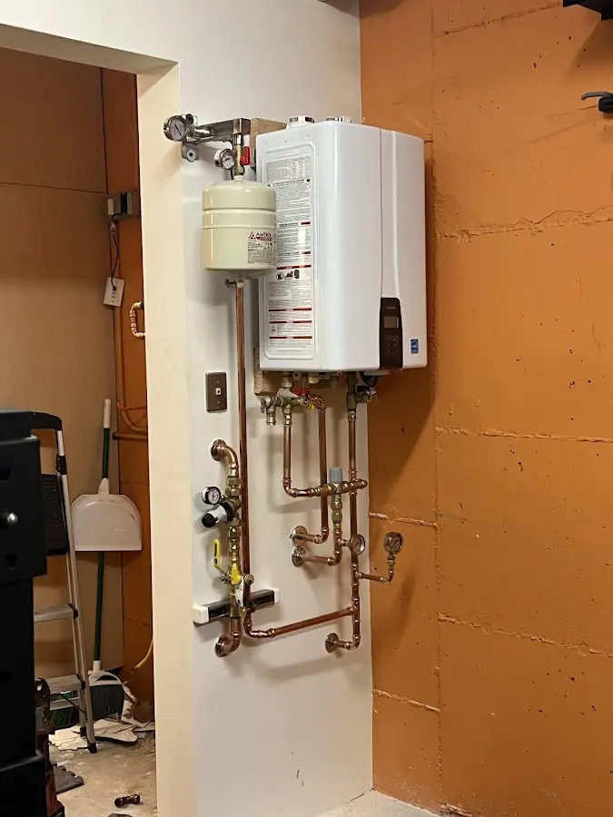 Plumbing technician inspecting water heater connections in Severance
